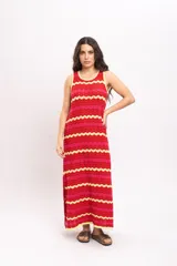 Vestido largo de tejido de punto con diseño de rayas en zigzag de colores rojo, fucsia y amarillo. Presenta cuello redondo y diseño sin mangas.