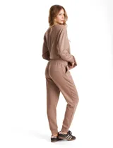 Jogger deportivo de corte holgado, con cintura elástica y lazo de ajuste, bolsillos laterales y puños elásticos en los tobillos.