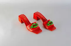 Sandalias tipo sueco color amarillo, con taco ancho y aplique de cadena en el empeine.