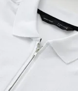 Remera polo blanca de algodón con cuello inglés y cremallera.