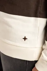 Sweater tipo polo de algodón con diseño de rayas horizontales anchas en color marrón y crema. Presenta cuello camisero, cierre frontal con botones ocultos y mangas largas con puños ajustados.