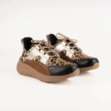 Championes deportivos de cuero en tonos marrón, tostado y marrón oscuro, con detalles de estampado animal print de leopardo en el lateral, suela gruesa blanca y cordones elásticos.