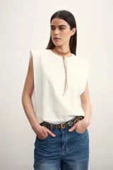 Remera blanca sin mangas con hombreras marcadas y cuello redondo.