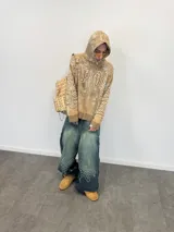 Buzo tipo hoodie con cierre frontal completo, confeccionado en tejido de punto grueso de algodón con diseño gráfico abstracto y tipográfico. Presenta capucha con bordado, puños y ruedo acanalados, y etiqueta de marca en la manga.