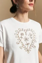 Remera de manga corta color marrón, con estampado central de corazón en color lila.