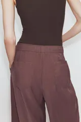Pantalón de tiro medio con corte estilo balloon, cintura elástica ajustable con cordones, bolsillos laterales ocultos y bolsillos de plastrón en la parte trasera.