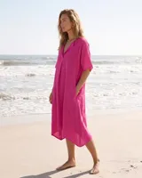 Vestido estilo túnica color fucsia de lino, con escote en V, manga corta, bolsillos laterales y diseño asimétrico más largo en la parte trasera.