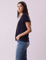 Remera blanca de lino con mangas cortas y fruncido en los hombros.