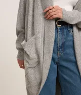 Cardigan alargado de punto color gris, sin cierre frontal y con mangas largas.