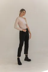 Body negro de lycra con un hombro descubierto y manga larga.