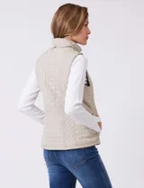 Chaleco capitoneado color verde oliva, con cuello alto, cierre frontal completo y bolsillos laterales. El interior está completamente forrado en símil piel para mayor calidez.