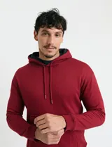 Sweater deportivo con capucha, bolsillo canguro frontal y cordones de ajuste. Presenta un diseño de color azul oscuro con interior de capucha en color verde.