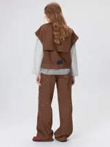 Campera de denim a rayas verticales con cuello de pana en color bordó. Presenta cierre frontal, mangas desmontables con cierre en los hombros, canesú en el pecho y bolsillos de parche cuadrados.