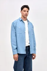 Camisa de corte regular fit confeccionada en algodón, con cuello solapa clásico, cierre frontal de botones y dos bolsillos frontales en el pecho.