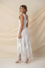 Vestido midi de tul color blanco con aplicaciones de encaje en festones, diseño sin mangas con escote en V y falda de corte irregular.
