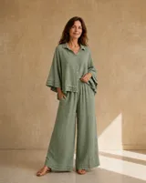 Camisa oversize color verde seco, de manga corta ancha con detalles de volados escalonados en los puños, cuello camisero clásico y cierre frontal de botones.