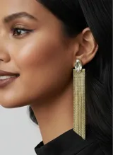 Caravanas largas de metal color dorado con diseño de flecos de malla y un cristal transparente en forma de marquesa en la parte superior.