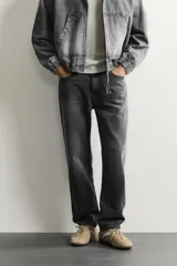 Pantalón de jean corte slim fit con efecto lavado, tiro medio, cinco bolsillos y cierre frontal con cremallera y botón.