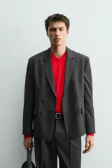 Blazer de corte regular confeccionada en tejido con lana, con diseño de botonadura cruzada. Presenta cuello con solapas de pico, manga larga con puños abotonados, bolsillos de solapa en la cadera y abertura central en la espalda.