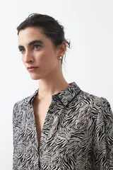 Camisa de manga larga color marrón con estampado de lunares blancos, confeccionada en tejido liviano con cuello clásico y botones frontales.