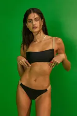 Conjunto de bikini negro con breteles color piel, corpiño tipo top con frunces en los laterales y bombacha vedetina con elástico fijo en los laterales.
