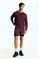 Remera deportiva de manga larga color bordó, con cuello redondo y tejido funcional con textura microperforada.