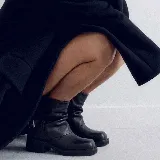Bota corta de cuero color negro, con diseño slouchy de caña arrugada, taco cuadrado bajo y detalle de tira con hebilla lateral. Cuenta con punta cuadrada.