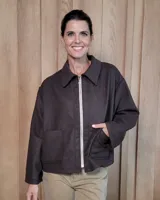 Chaqueta de paño color marrón oscuro, con corte oversize, cuello camisero, cierre frontal plateado y dos bolsillos frontales tipo parche.