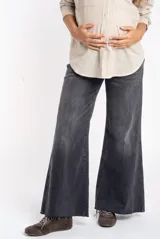 Jean de corte wide leg y tiro medio, color gris con efecto lavado. Presenta un diseño de pierna ancha con ruedo desflecado.