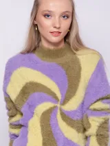 Polera de tejido de punto con diseño de jacquard en espiral en tonos celeste, rosa y naranja. Es de textura peludita, manga larga y cuello alto.