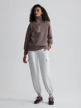 Buzo color marrón topo de tejido acanalado con cierre de cremallera metálica y cuello alto.