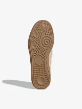 Mocasines Adidas Handball Spezial confeccionados en gamuza color beige, con diseño inspirado en el calzado deportivo clásico. Presentan las icónicas tres bandas laterales, una tira frontal con detalle de logo dorado y suela de goma color caramelo.