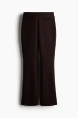 Pantalón de tiro alto confeccionado en punto roma, con diseño ajustado en la parte superior y piernas acampanadas. Presenta bolsillos insertados decorativos en la parte frontal.