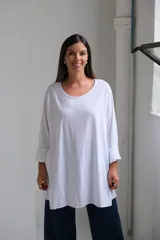 Remera blanca de corte oversize y diseño holgado, con cuello redondo y mangas largas con puños doblados.