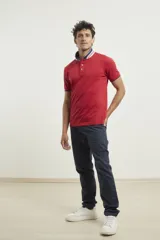 Chomba de piqué azul con cuello clásico, mangas cortas y corte recto. El cuello y los puños tienen detalles a contratono en azul marino y blanco.