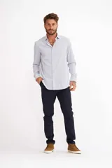 Camisa de manga larga con diseño de rayas verticales blancas y azules, cuello camisero y cierre frontal con botones.