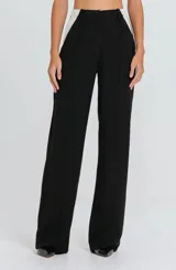 Pantalón de sastreria negro de corte recto y tiro alto, con detalles en contraste de color blanco en los laterales de la cintura y trabillas para cinto.