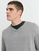 Sweater de punto color ladrillo con cuello en V y mangas largas.