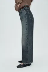 Jeans de tiro alto color azul claro, con cinco bolsillos y pernera recta que se estrecha hacia el tobillo. Incluye un cinturón negro con detalles metálicos. Cierre frontal con cremallera y botón.