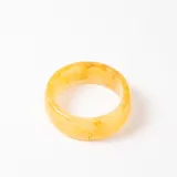 Brazalete rígido de resina en tono amarillo traslúcido con efecto jaspeado.