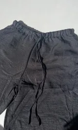 Pantalón negro de tiro alto y corte palazzo con cordón ajustable en la cintura.
