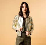 Chaqueta corta plateada de cuero sintético, corte recto y estilo Chanel. Sin forro.