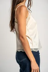 Blusa satinada marrón con detalles de encaje en el escote en V y en el ruedo. Presenta tirantes finos regulables.
