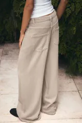 Jeans de tiro alto con diseño de pierna ancha y cinco bolsillos. Cuenta con cierre frontal mediante cremallera y botón metálico.