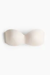 Soutien strapless de microfibra en color beige con copas acolchadas, tirantes ajustables y desmontables, y cierre posterior de corchetes.