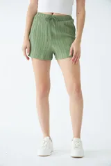 Short negro de poliéster con cintura elástica, cordón ajustable y bolsillos laterales.