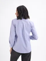 Camisa de corte clásico con estampado de rayas verticales finas en color azul y blanco, cuello camisero y cierre frontal con botones.