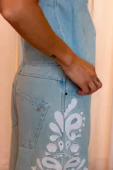 Jeans de mezclilla de silueta barrel y bota ancha, color celeste claro, con apliques bordados florales tono sobre tono en los laterales de las piernas, bolsillos delanteros y diseño de tiro medio.