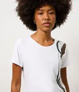 Remera deportiva de mujer Get Over, confeccionada en microfibra blanca con cuello redondo, manga corta y un diseño estampado de ondas en color verde y marrón en el lateral izquierdo.