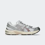 Championes Asics modelo Gel 1130, color blanco con detalles plateados y acentos en tono rosado y bordó. Diseño de inspiración retro y estética running con malla transpirable y superposiciones sintéticas.
